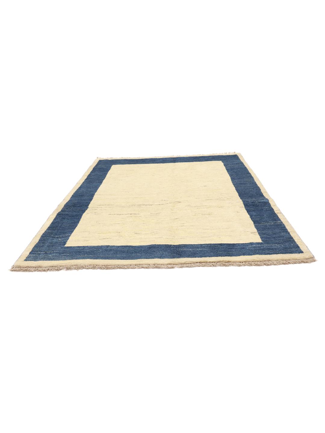 Tapis Gabbeh noué à la main venant du Moyen-Orient avec un champ beige et une bordure bleu foncé.
