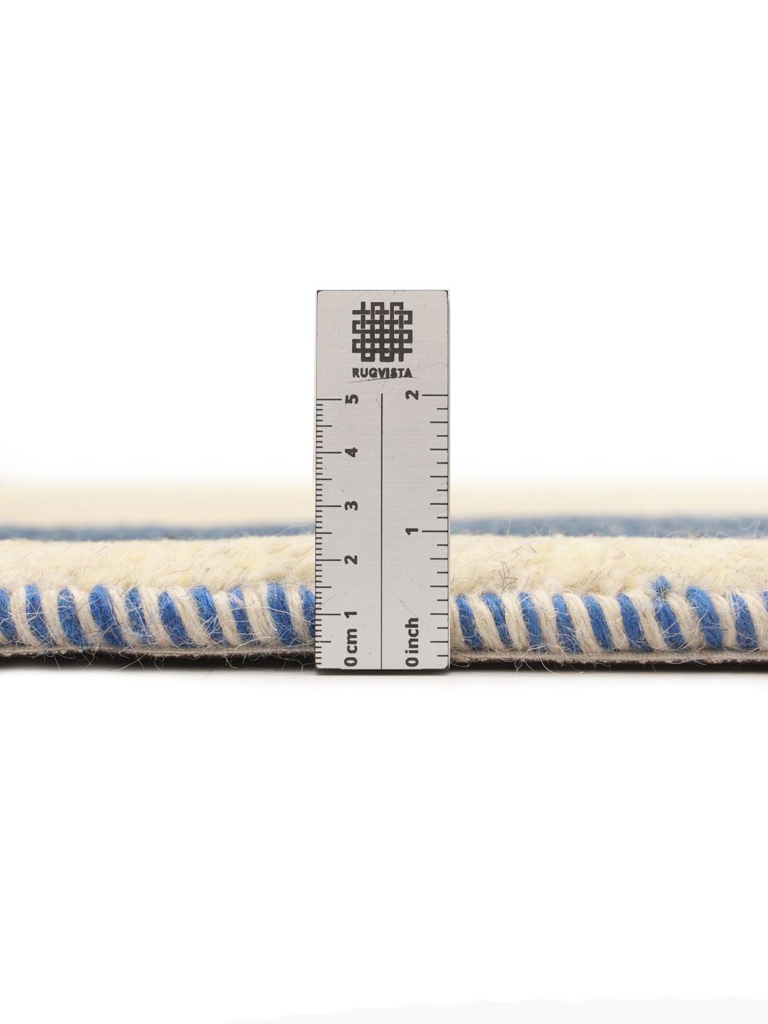 Tapis Gabbeh noué à la main venant du Moyen-Orient avec un champ beige et une bordure bleu foncé.
