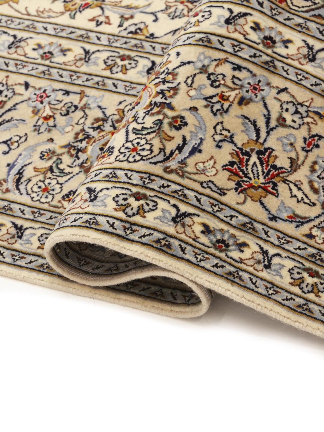 Een handgeknoopt Keshan-tapijt uit het Midden-Oosten in beige tinten met bloemmotieven.