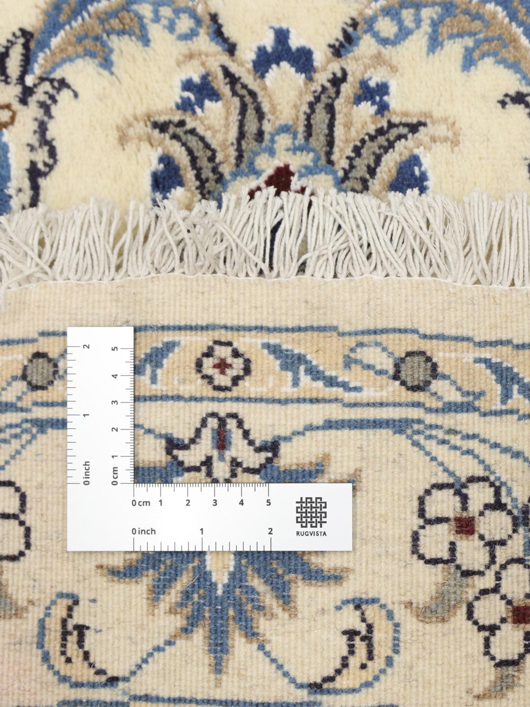 Et rundt Nain-tæppe med komplekse blomstermønstre på en beige baggrund, med oprindelse fra Mellemøsten.