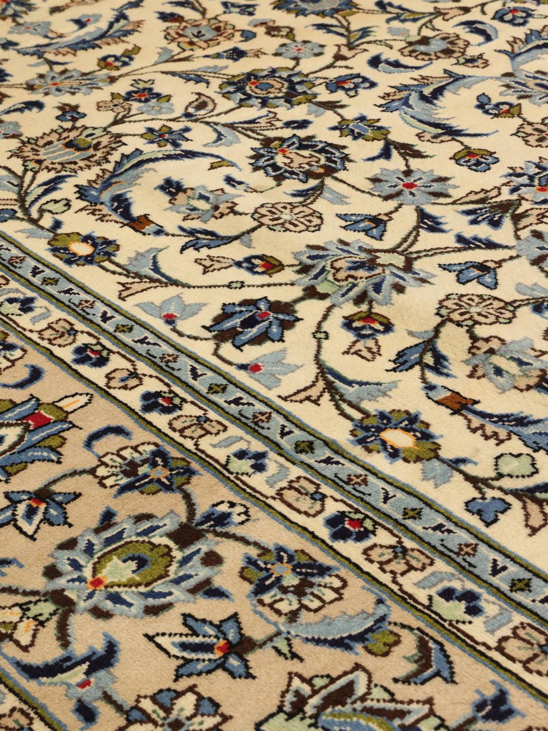Een handgeknoopt Keshan-tapijt uit het Midden-Oosten met een bloempatroon in beige en blauw.