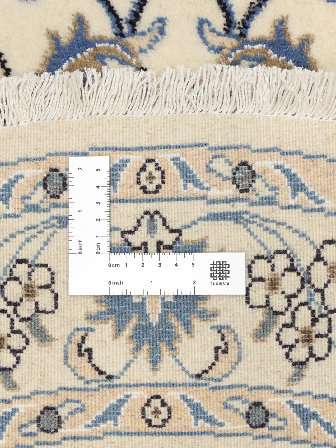 Rundt håndknyttet Nain-tæppe fra Mellemøsten med blomstermønstre i beige og blå.