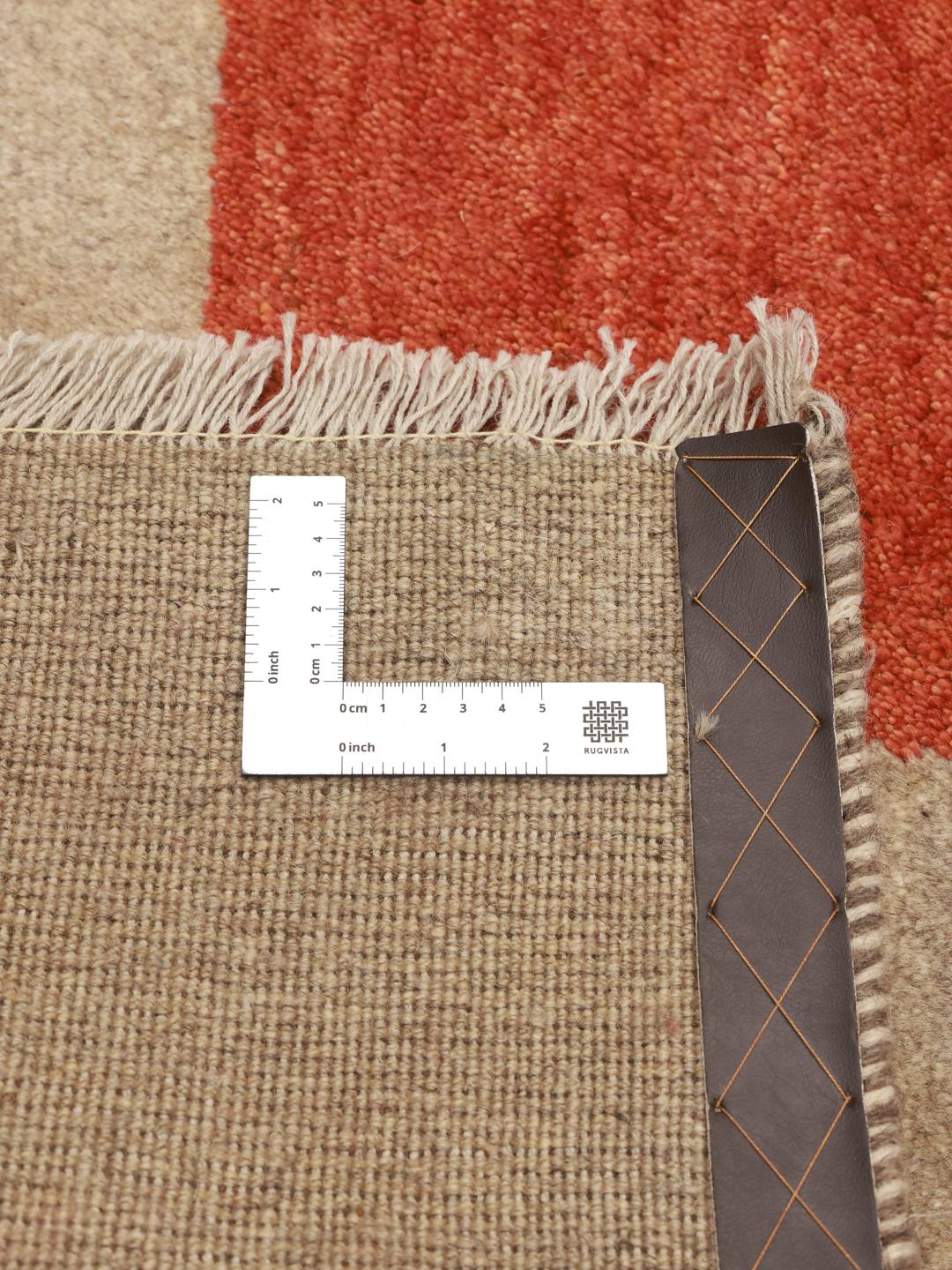 Håndknyttet Gabbeh-tæppe fra Mellemøsten med en beige flade og geometriske røde og brune accenter.