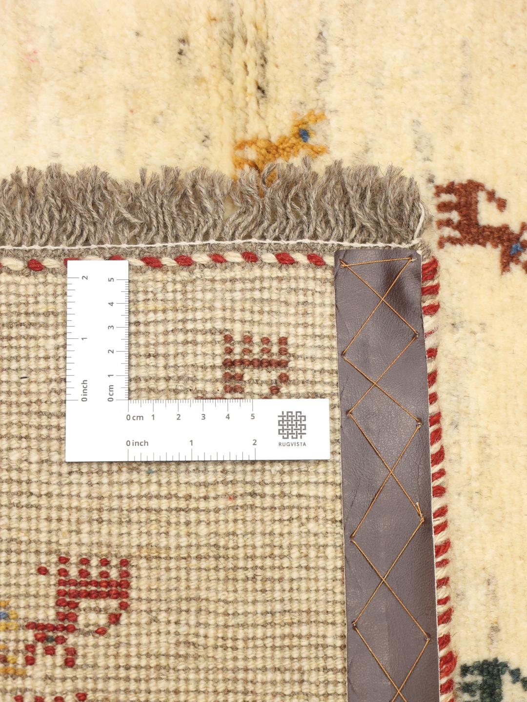 Hand-knotted Gabbeh rug with animal motifs on a cream wool field from the Middle East