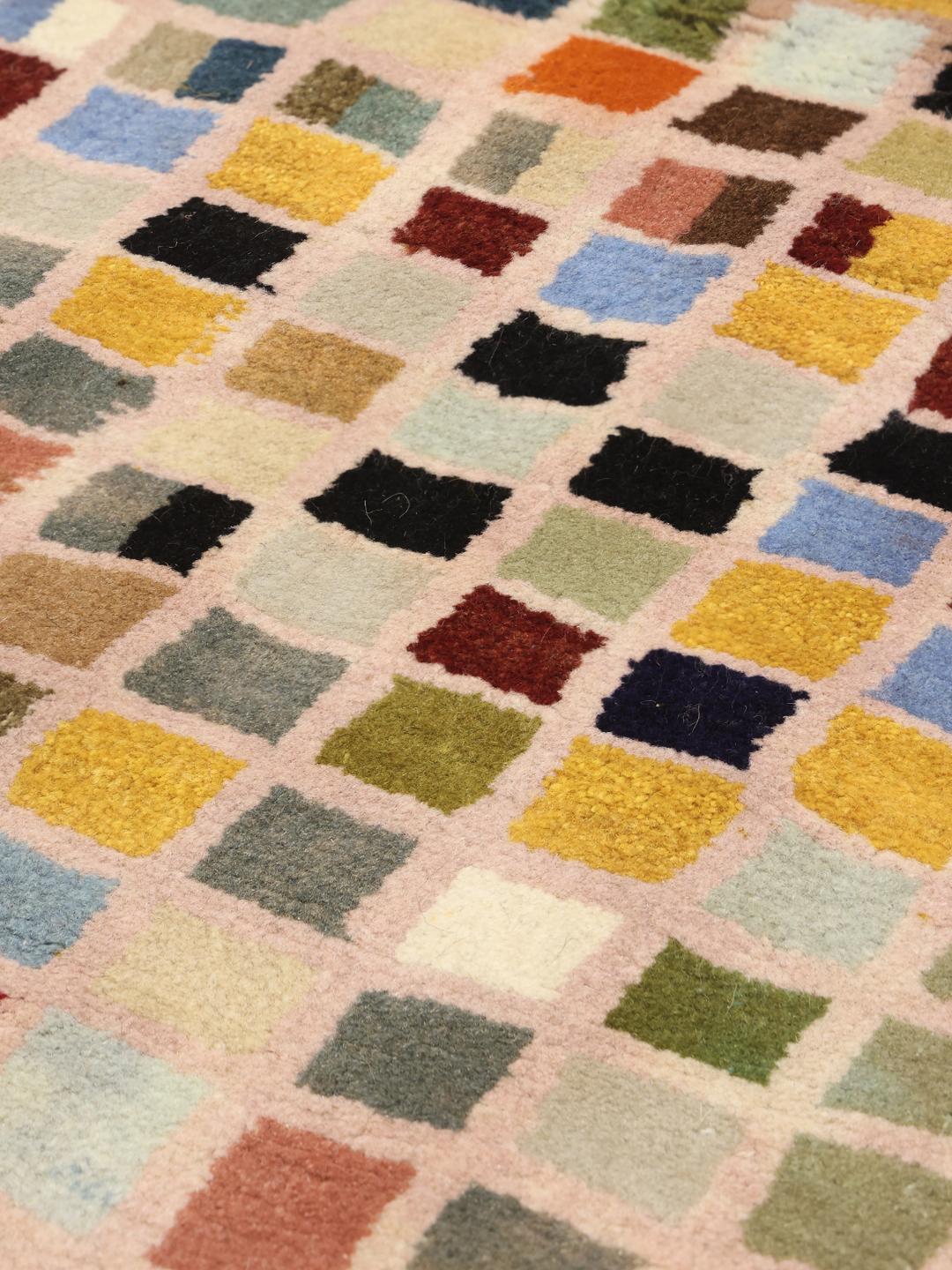 A hand-knotted Gabbeh rug from the Middle East with a multicoloured square grid pattern.