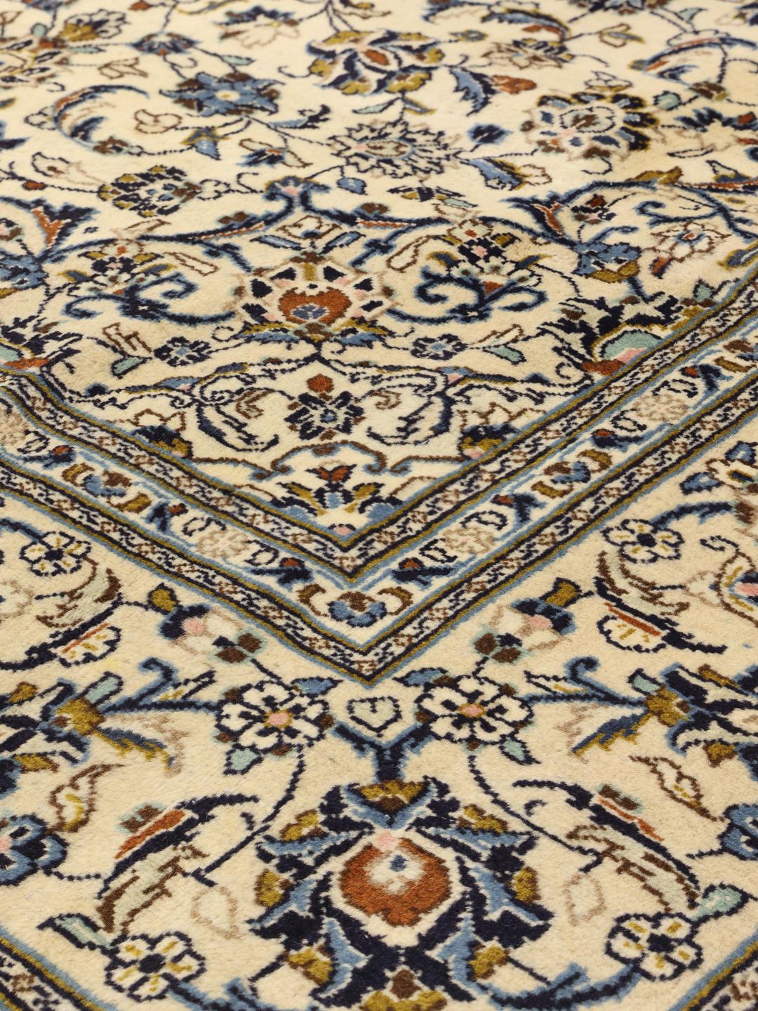 Hand-knotted Keshan rug with floral motifs and blue accents on a beige background from the Middle East