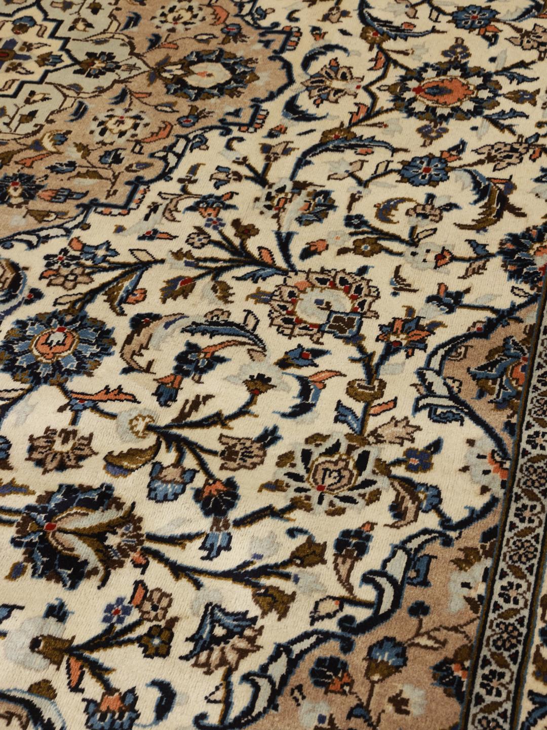 A hand-knotted Keshan rug from the Middle East with a beige background and floral patterns.