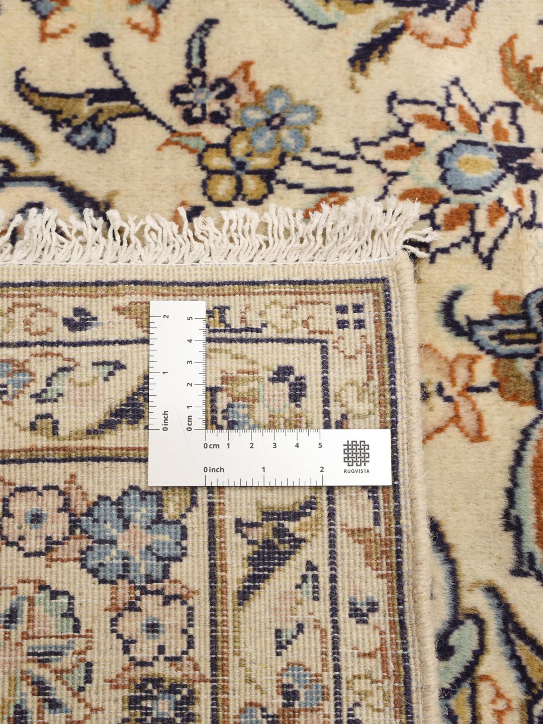 Et håndknyttet Keshan-tæppe fra Mellemøsten med en blomstermedaljon i beige og blå.