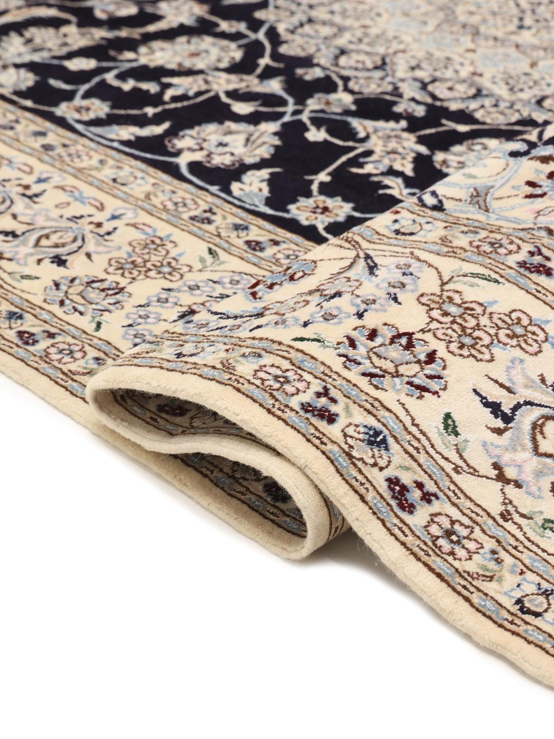 A hand-knotted Nain rug from the Middle East featuring a black field with light floral patterns.