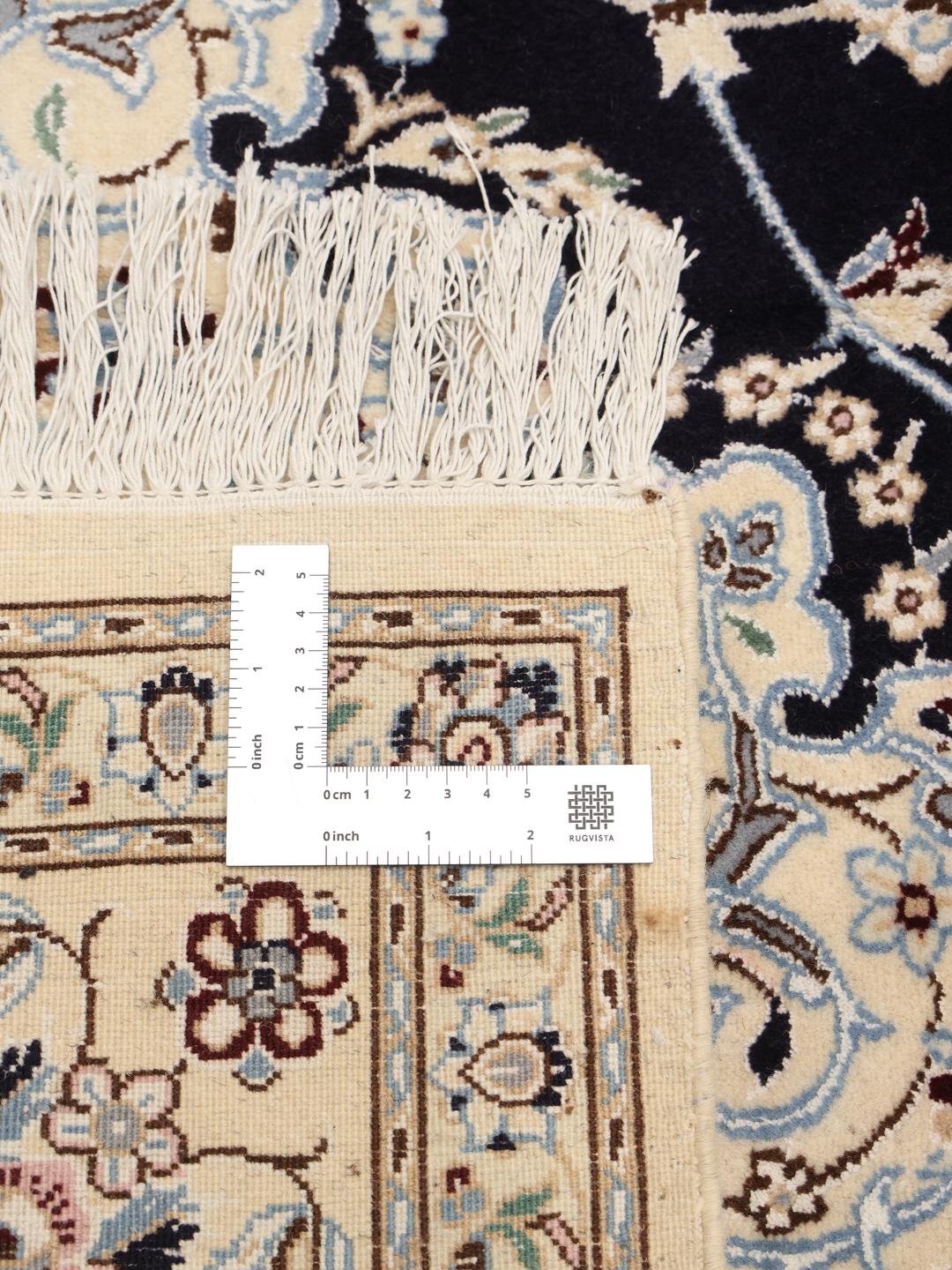 A hand-knotted Nain rug from the Middle East featuring a black field with light floral patterns.