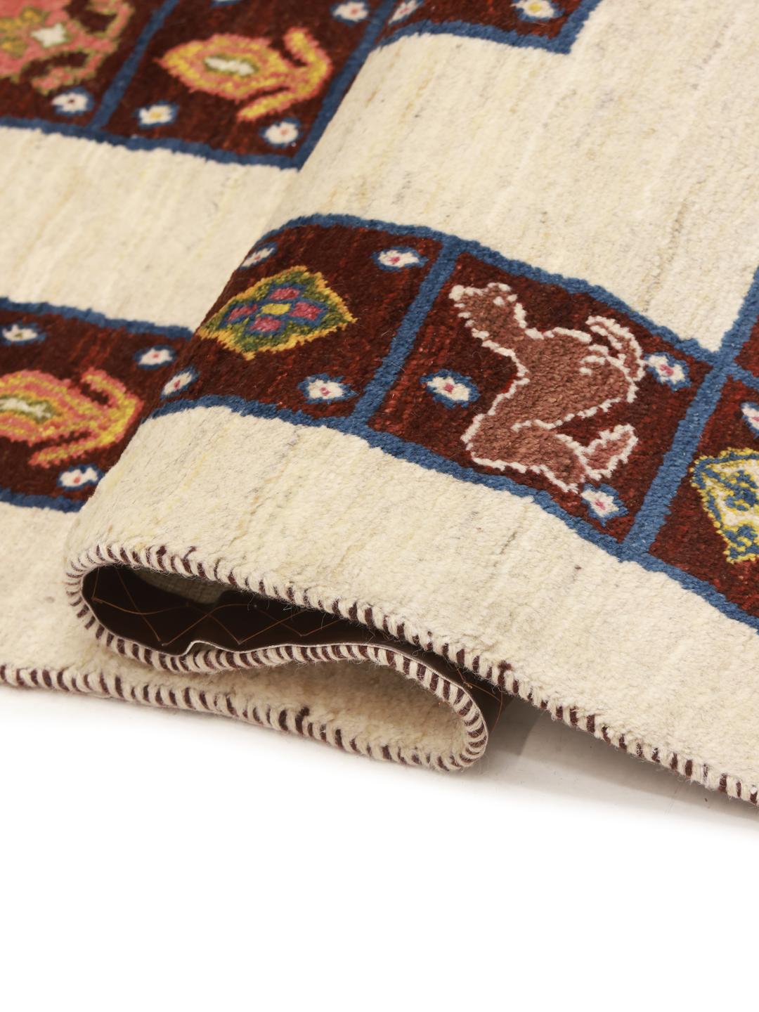 A hand-knotted Middle Eastern Shabargan rug in beige with dark red and blue accents.