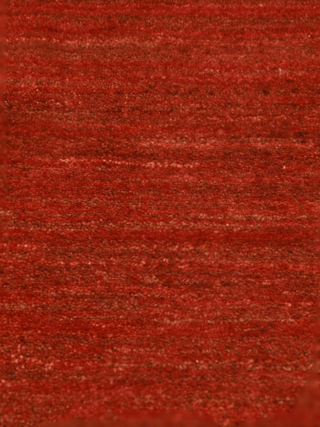 Un tapis Gabbeh noué à la main provenant du Moyen-Orient dans une riche couleur rouge foncé.