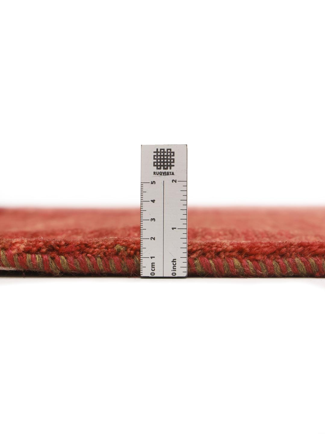 Un tapis Gabbeh noué à la main provenant du Moyen-Orient dans une riche couleur rouge foncé.