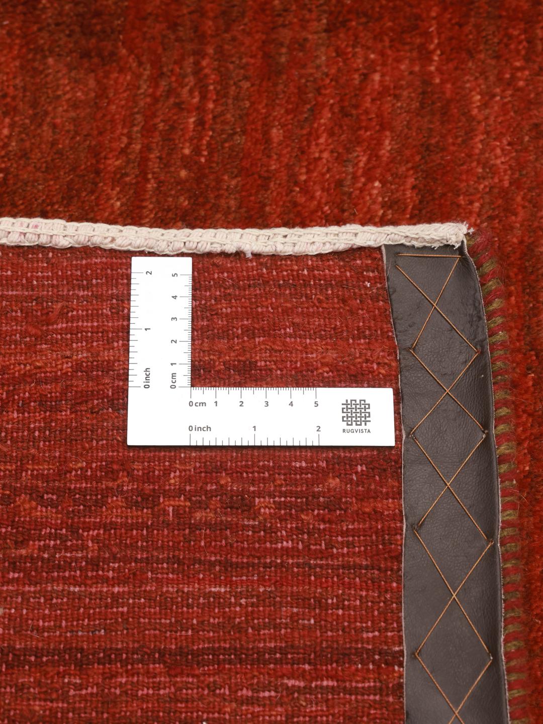 Un tapis Gabbeh noué à la main provenant du Moyen-Orient dans une riche couleur rouge foncé.