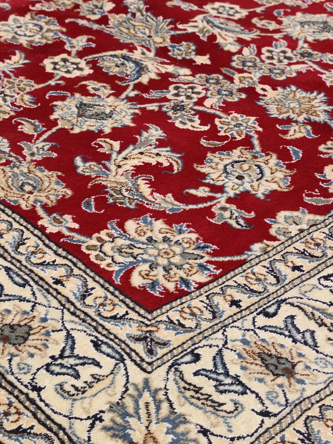 Hand-knotted Nain rug from the Middle East in deep red with floral patterns