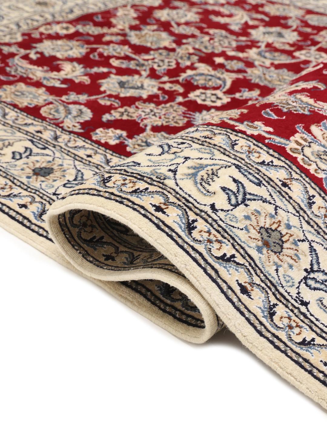 Hand-knotted Nain rug from the Middle East in deep red with floral patterns