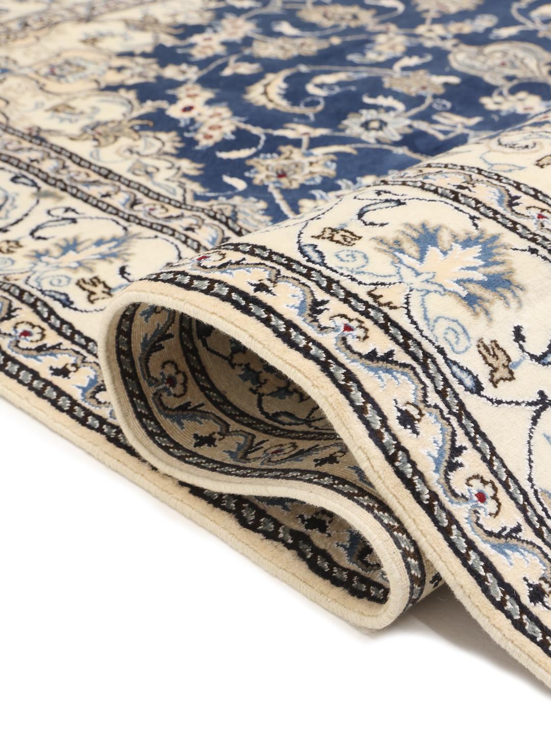 Hand-knotted Nain rug from the Middle East with a deep blue field and floral motifs