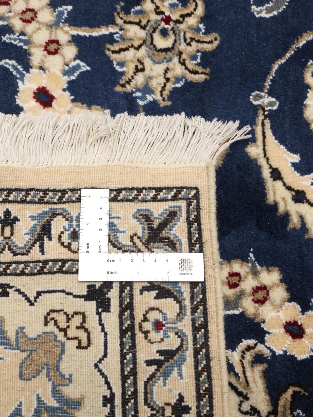 Hand-knotted Nain rug from the Middle East with a deep blue field and floral motifs