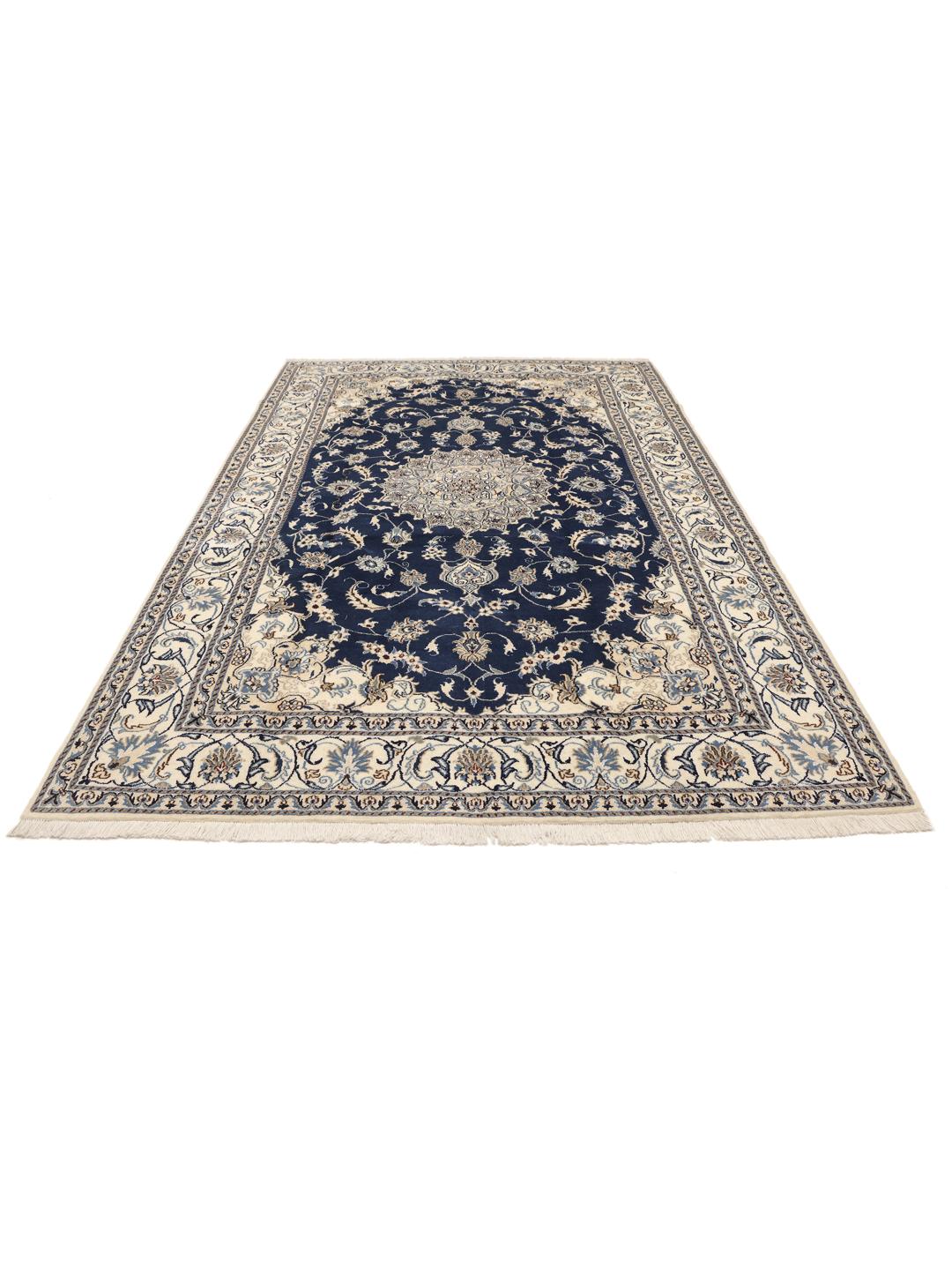 A hand-knotted Nain rug from the Middle East featuring a blue field with floral patterns.