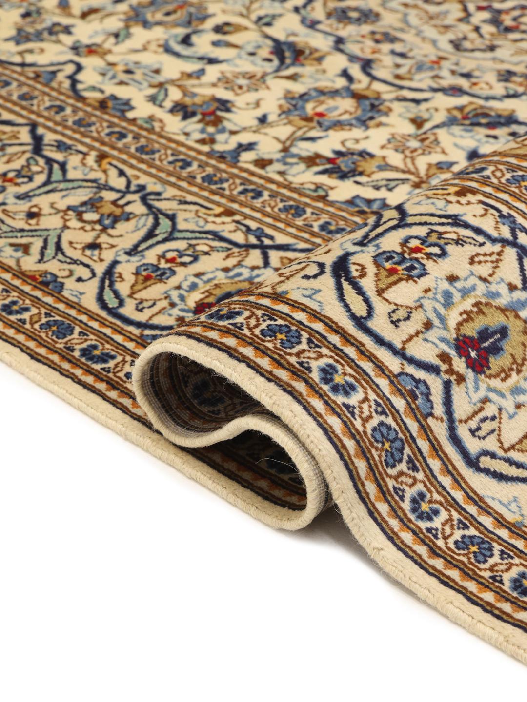 Een handgeknoopt Keshan tapijt uit het Midden-Oosten met een beige veld en blauwe bloemenmedaillonpatronen.