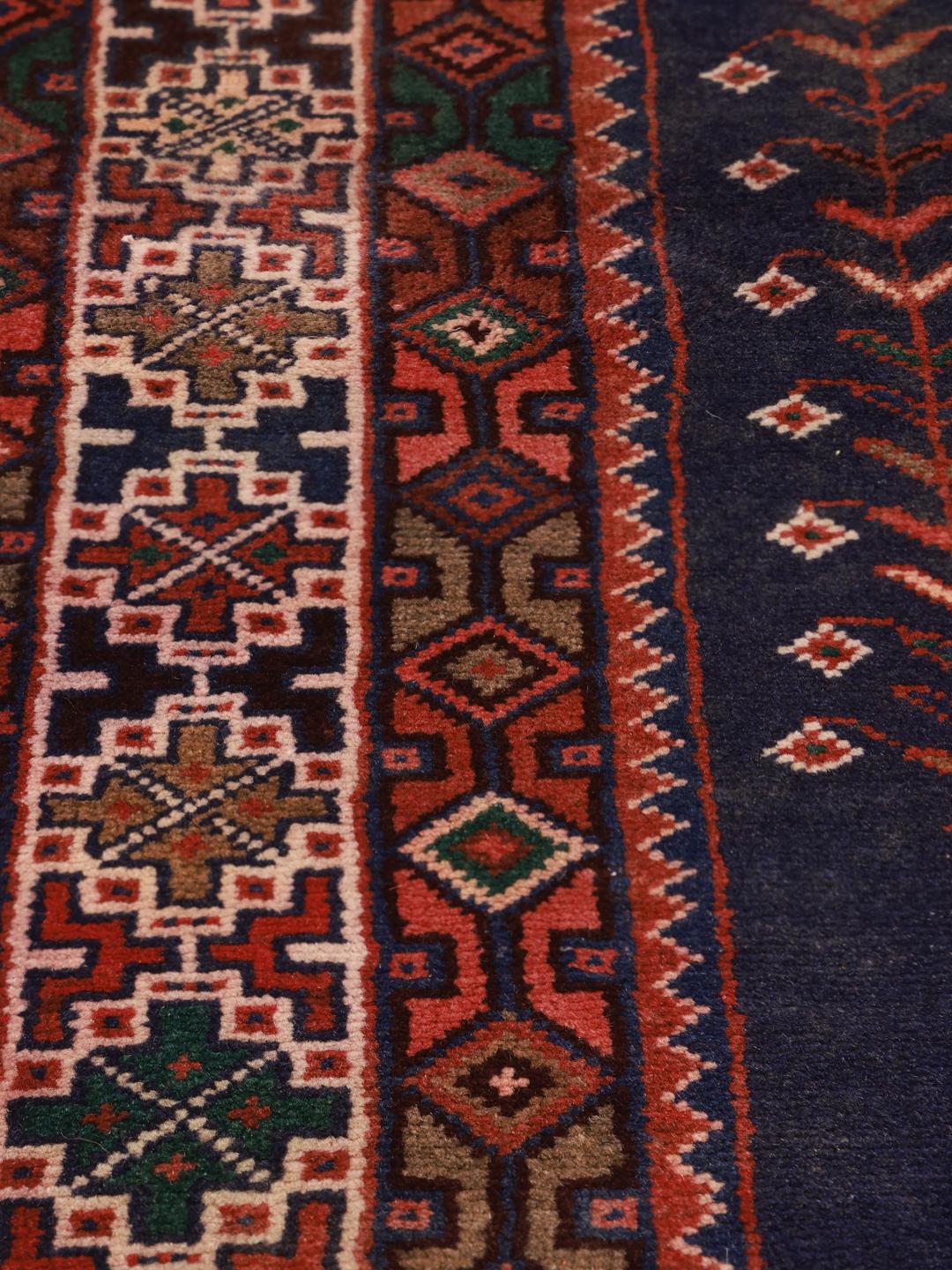 Håndknyttet Afshar-tæppe fra Mellemøsten med blåt felt og fuglemotiver.