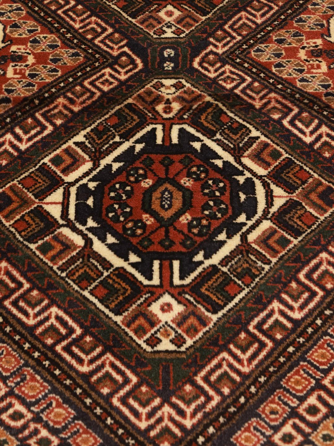 Handgeknoopt Afshar Shahre Babak tapijt uit het Midden-Oosten met een rood en donkerblauw geometrisch patroon.
