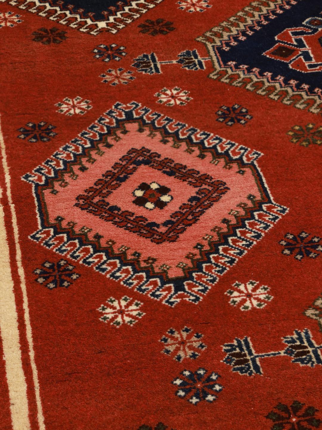 Handgeknoopt Yalameh-tapijt uit het Midden-Oosten met een rood veld en geometrische patronen
