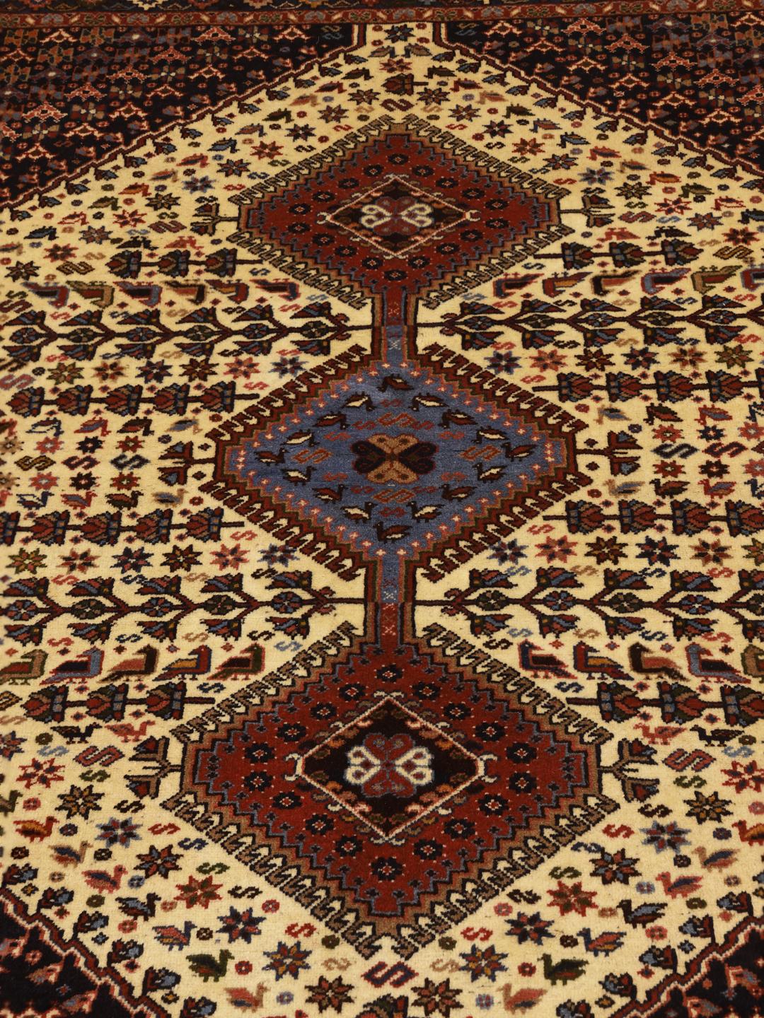 Een handgeknoopt Yalameh-tapijt uit het Midden-Oosten met een veelkleurig geometrisch ontwerp.