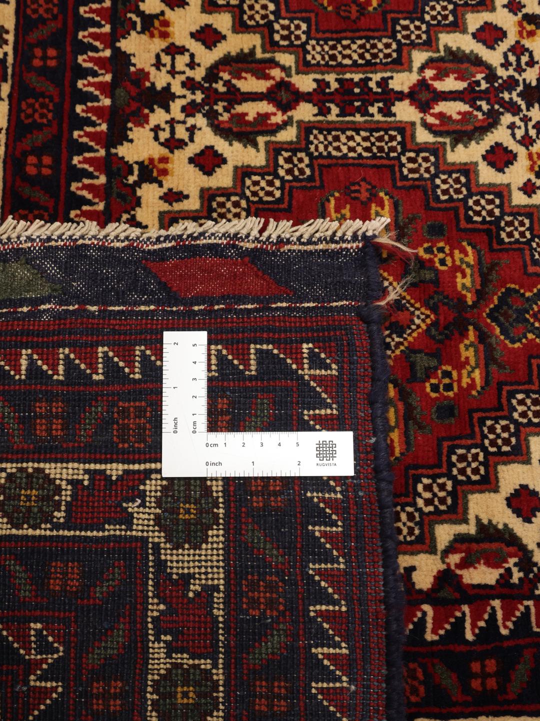 Handgeknoopt Afghaans Kunduz-tapijt in diepe donkerrode tinten met geometrische patronen.