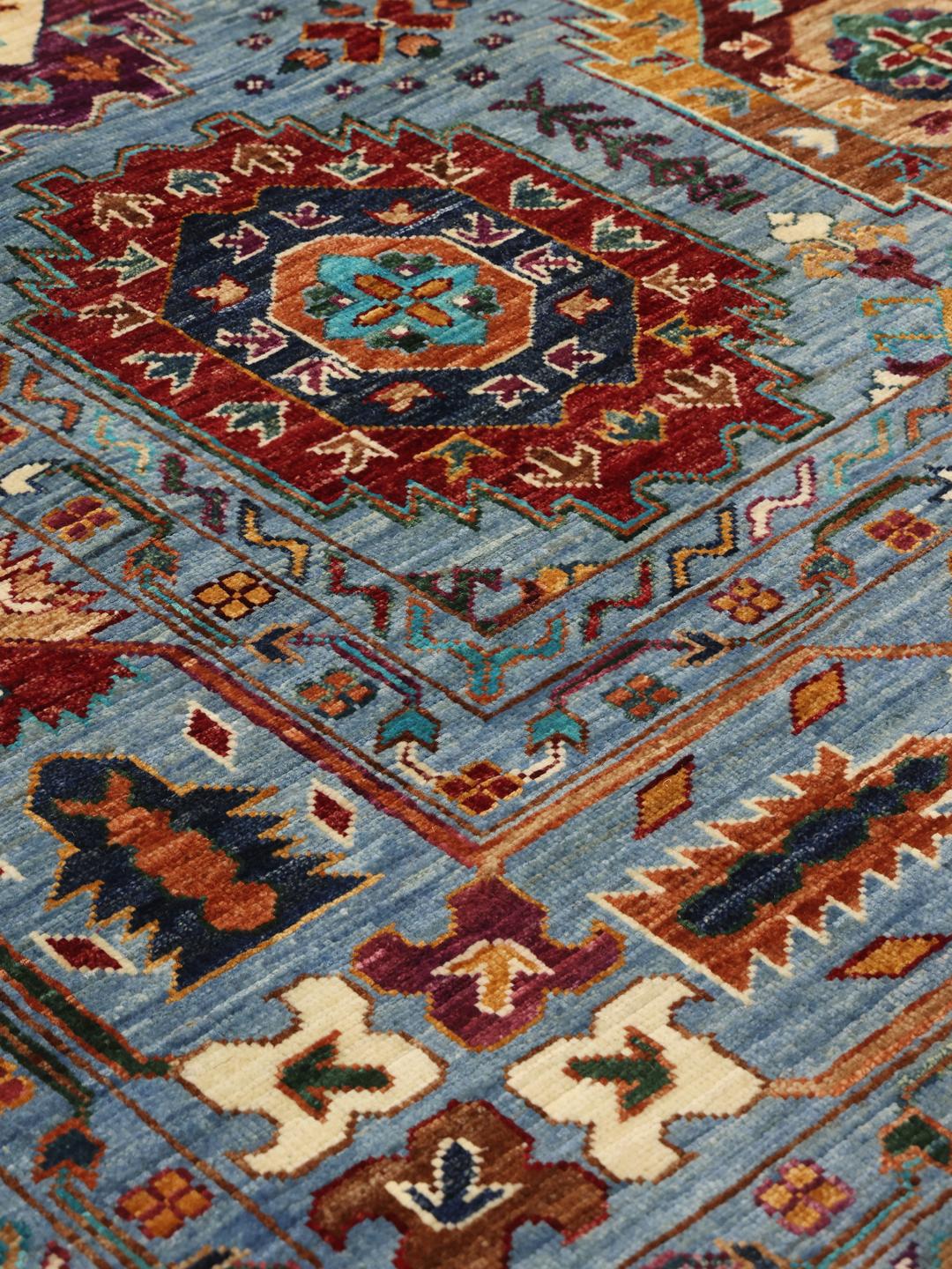 Een handgeknoopt blauw Afghaans tapijt met ingewikkelde kleurrijke medaillons