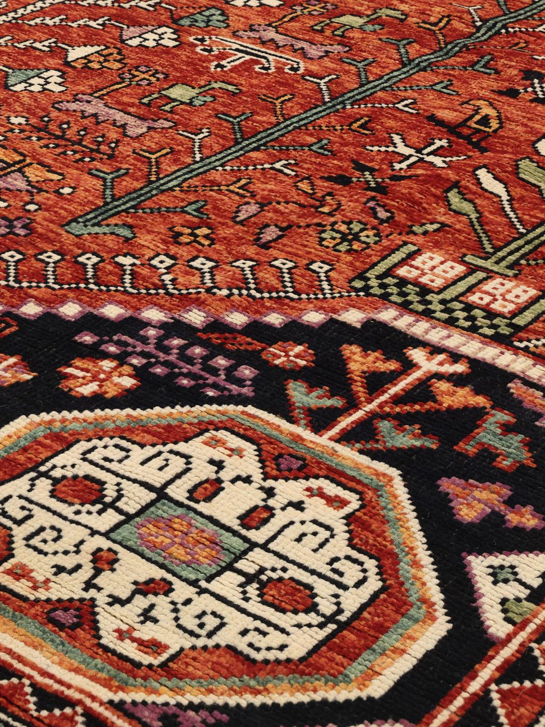 Handgeknoopt Kazak-tapijt uit Afghanistan met een gedurfd rood en donkerblauw geometrisch patroon.
