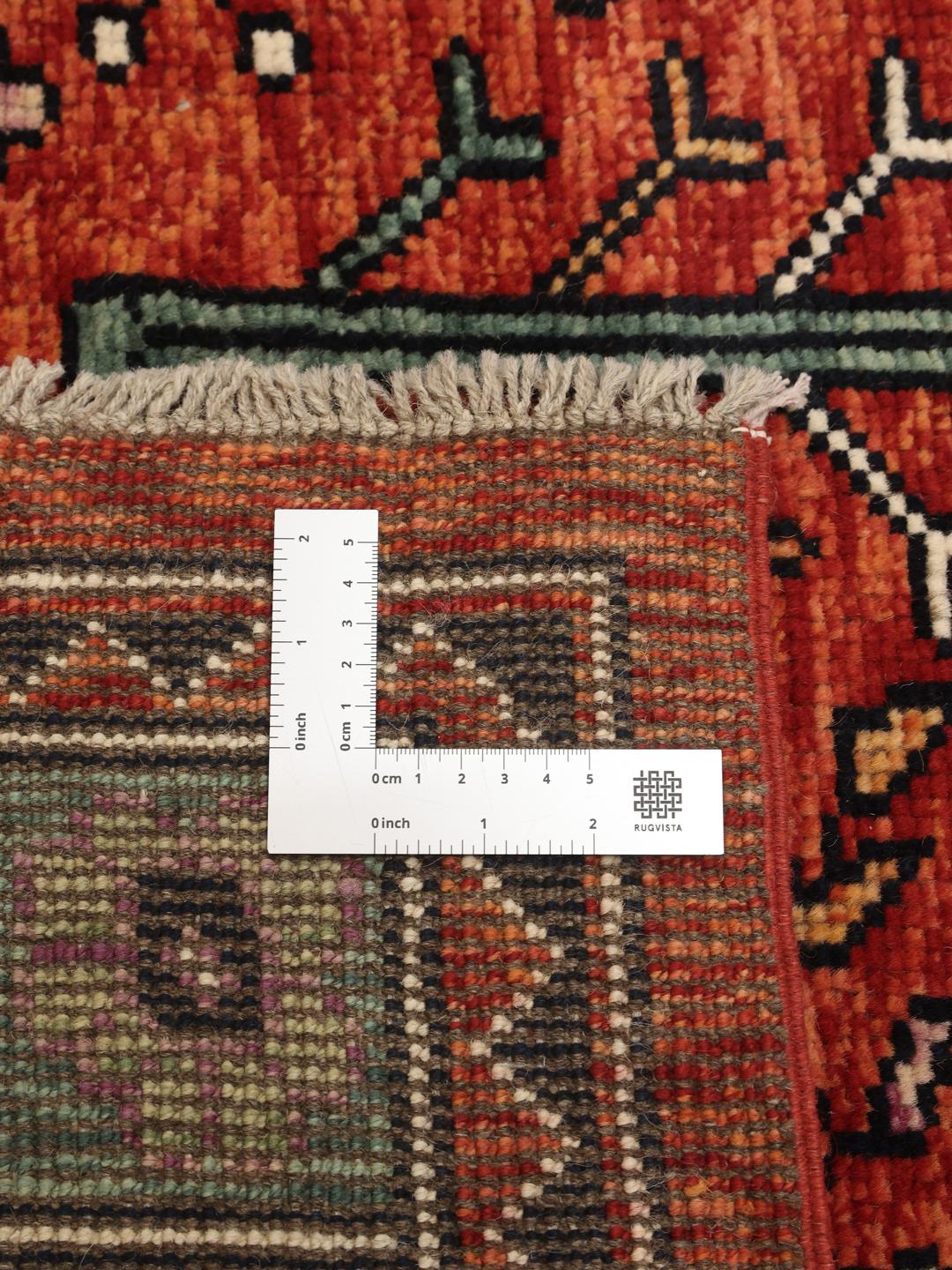 Handgeknoopt Kazak-tapijt uit Afghanistan met een gedurfd rood en donkerblauw geometrisch patroon.