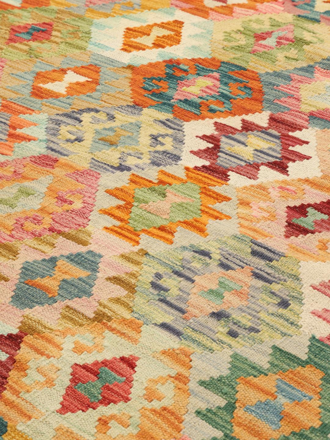 Håndvævet afghansk Kelim-tæppe med et farverigt geometrisk design.