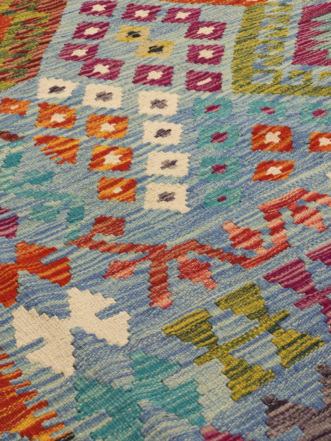 Hand-woven Kelim Afghan Old Style rug with a blue base and geometric diamond patterns.