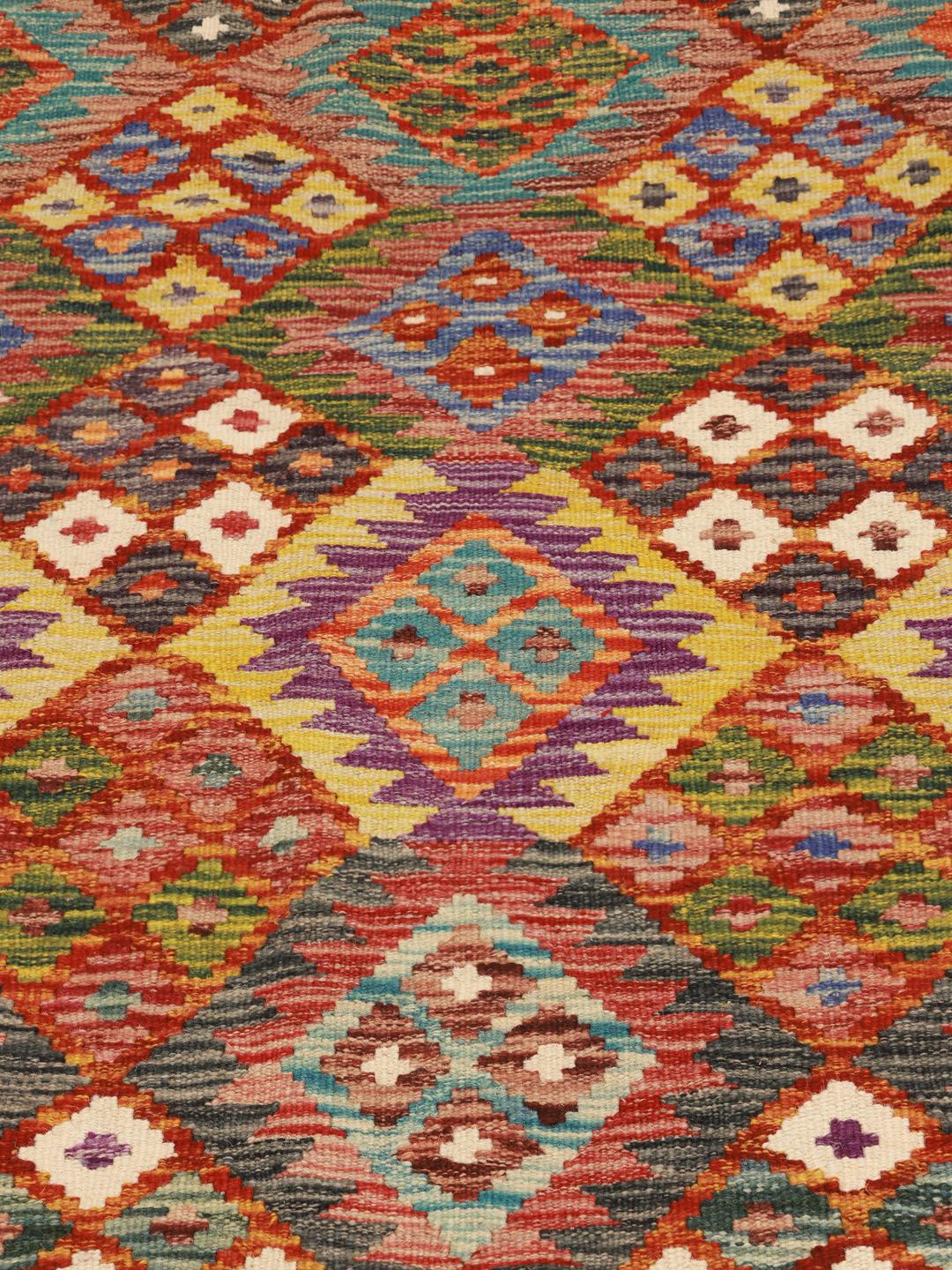A hand-woven Afghan kelim rug featuring a vibrant red field with intricate geometric patterns.