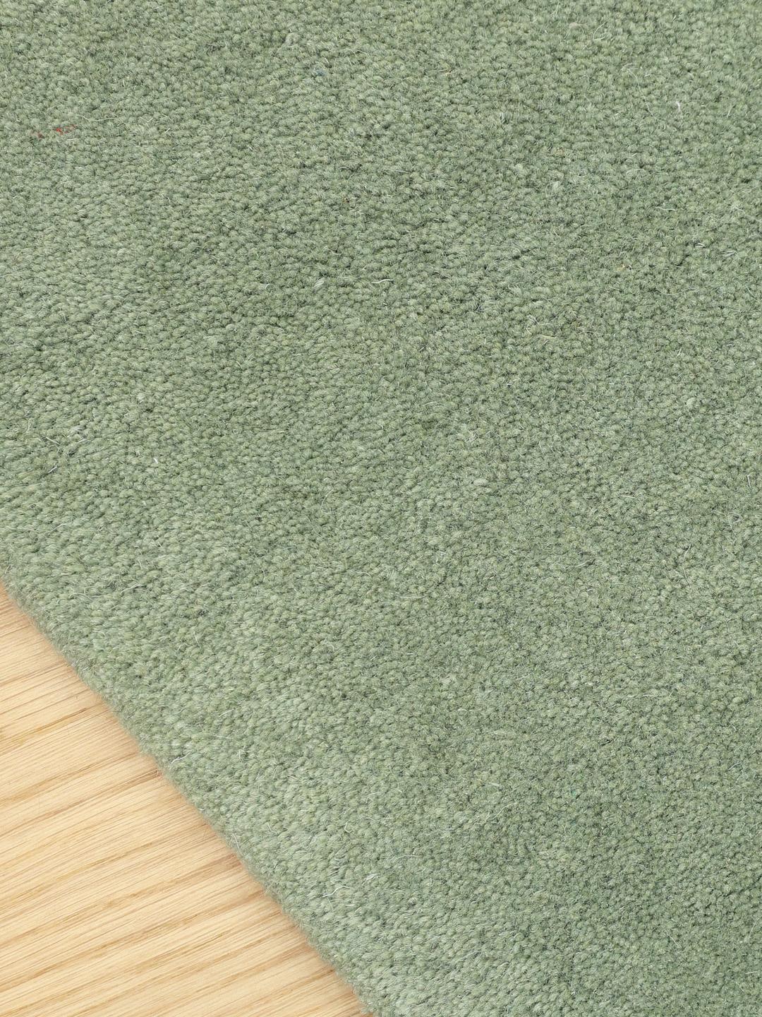 Tapis vert de forme organique en laine.