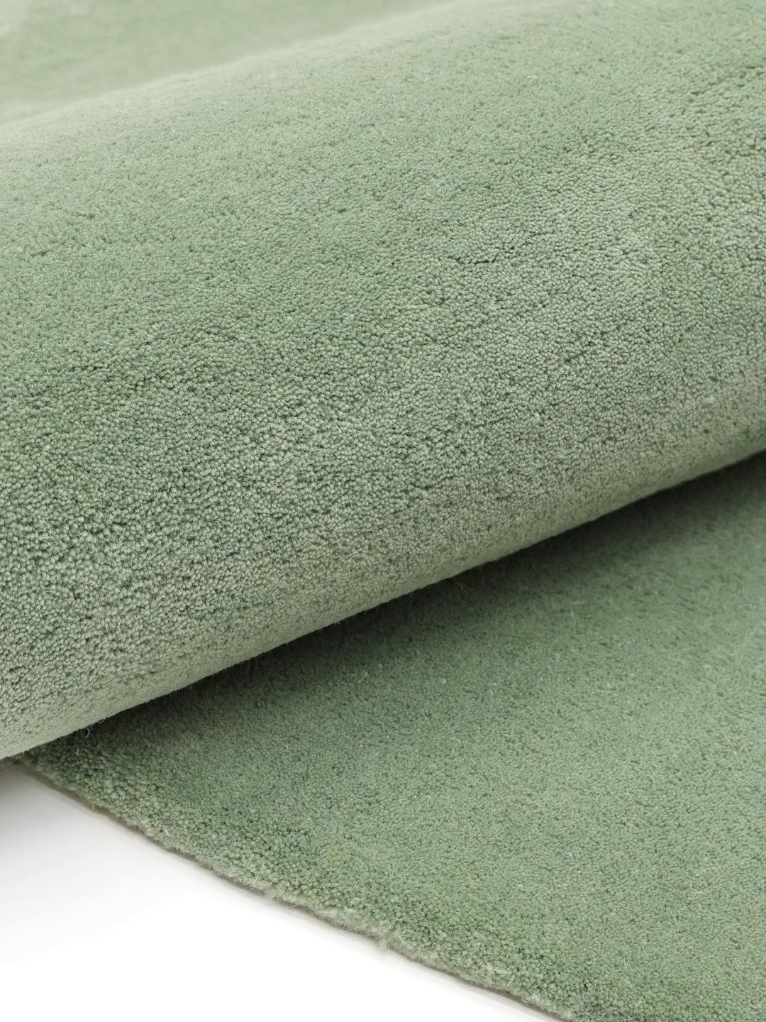 Tapis vert de forme organique en laine.