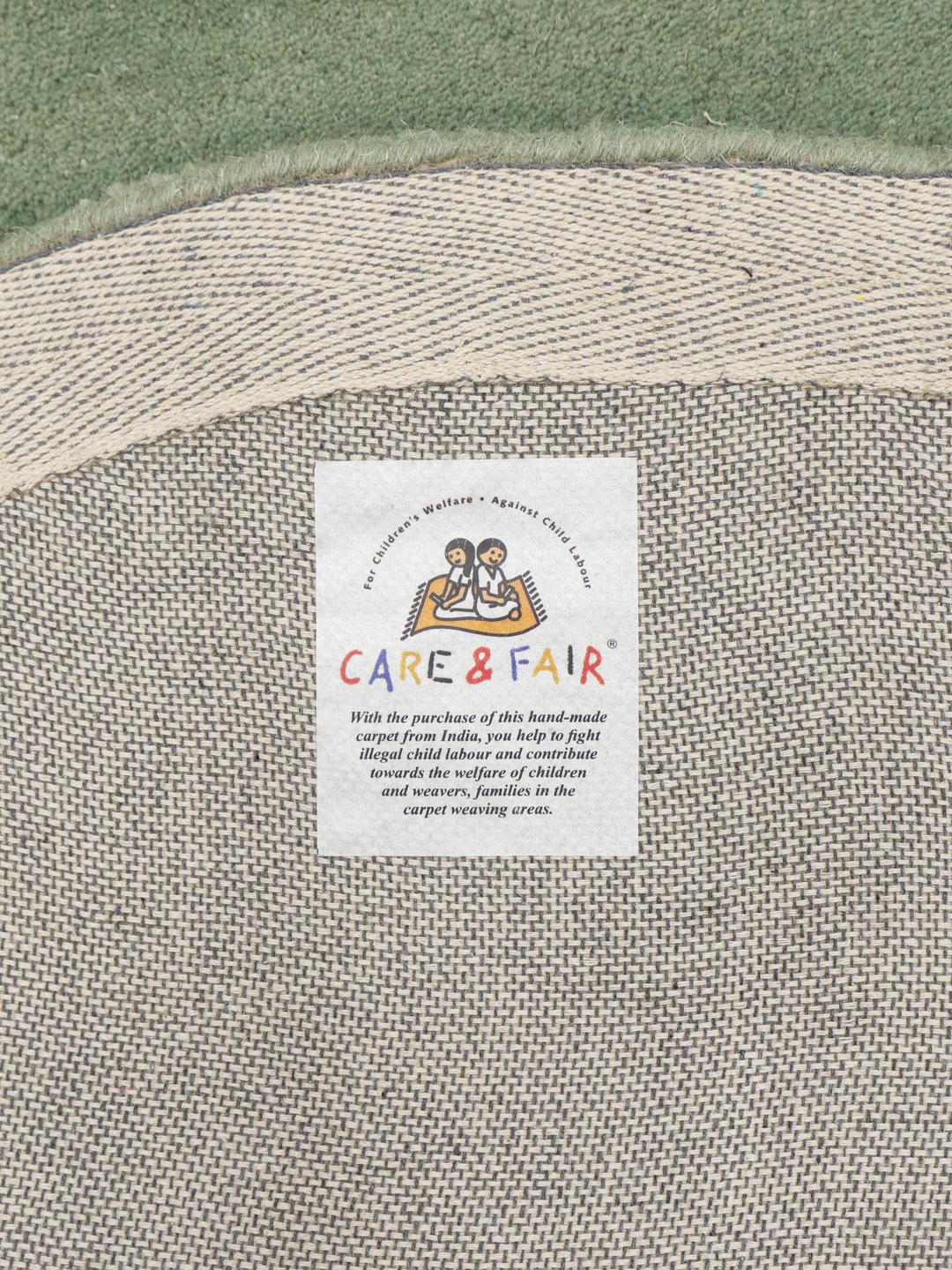 Tapis vert de forme organique en laine.