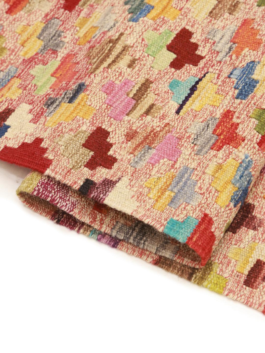 A large, one-of-a-kind Afghan Kelim rug with a vibrant, multicolored geometric pattern.