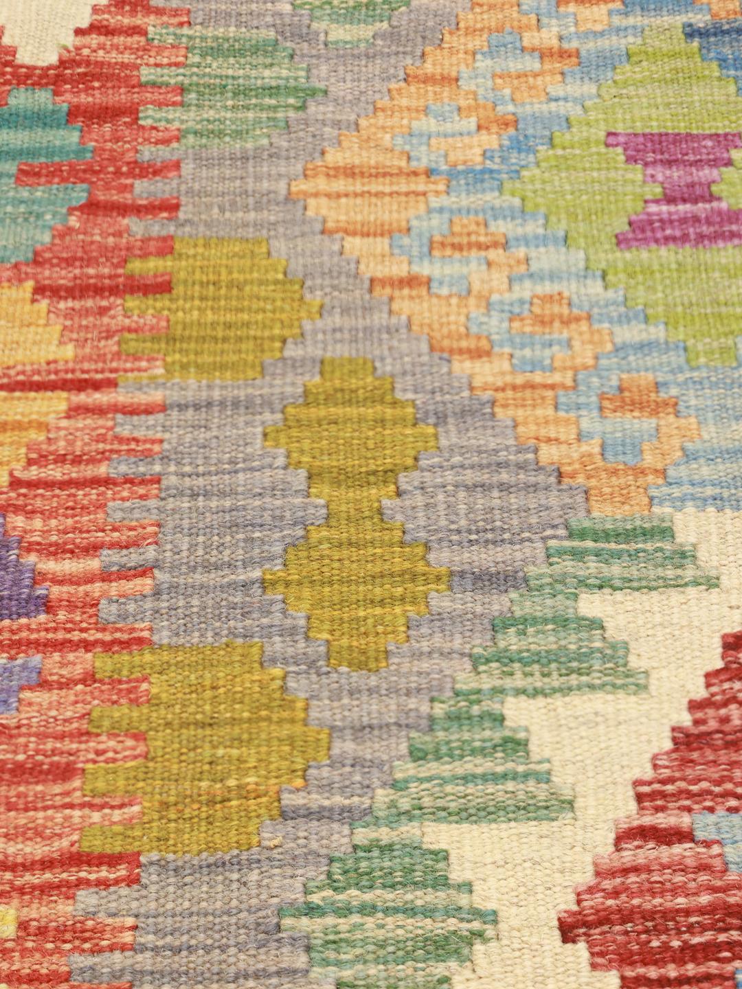 Hand-woven Afghan Kelim rug featuring a vibrant multicolor diamond pattern on a grey background