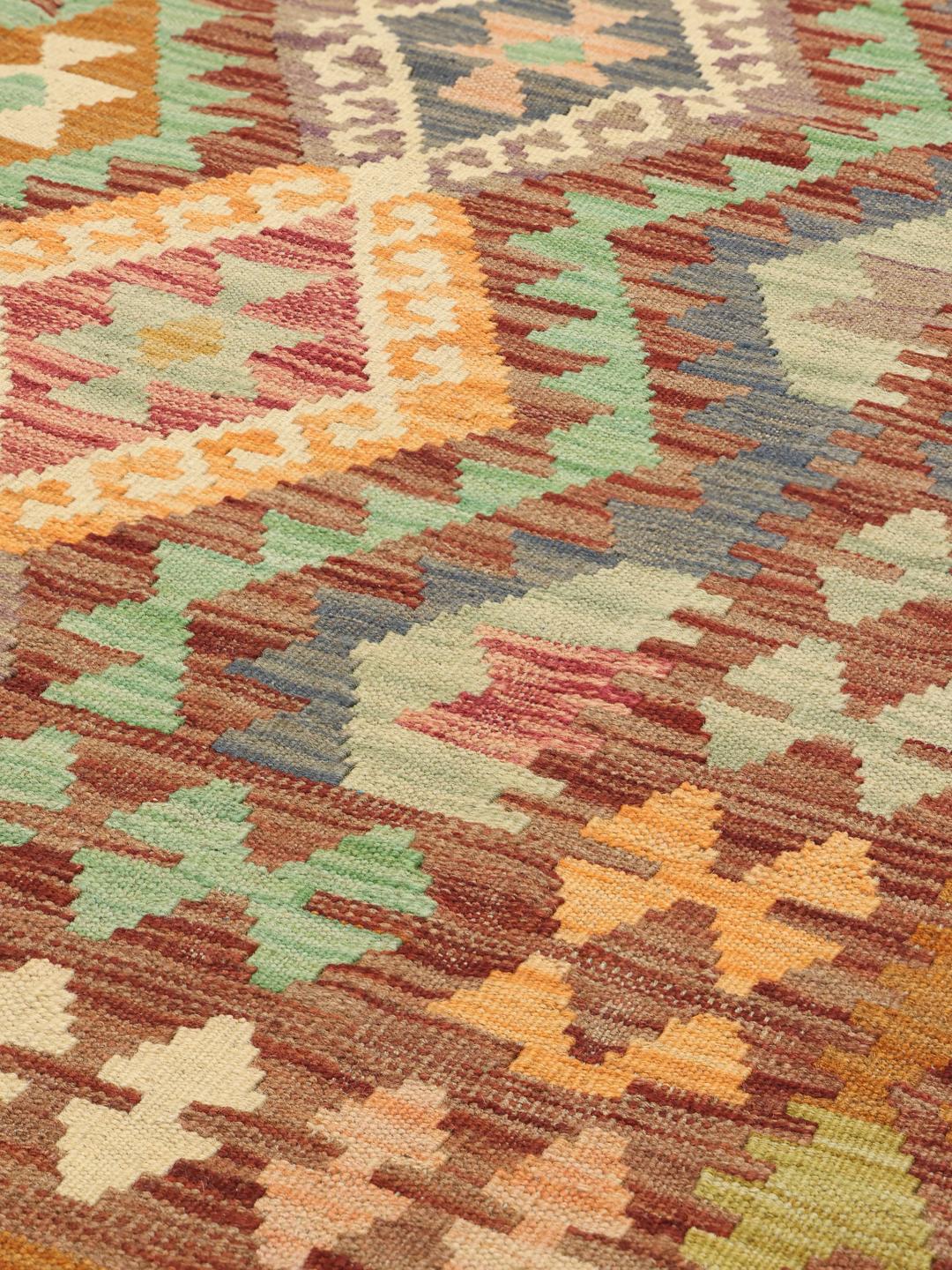 Hand-woven Afghan Kelim rug featuring a vibrant multi-coloured diamond pattern on a dark-red background.