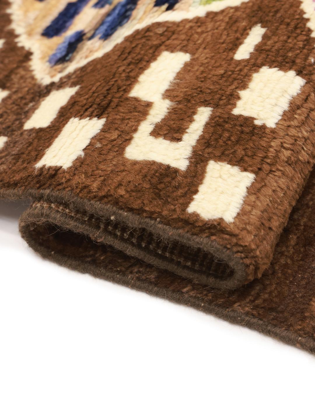 Hand-knotted Berber rug from Afghanistan with colourful diamond patterns on a brown background.