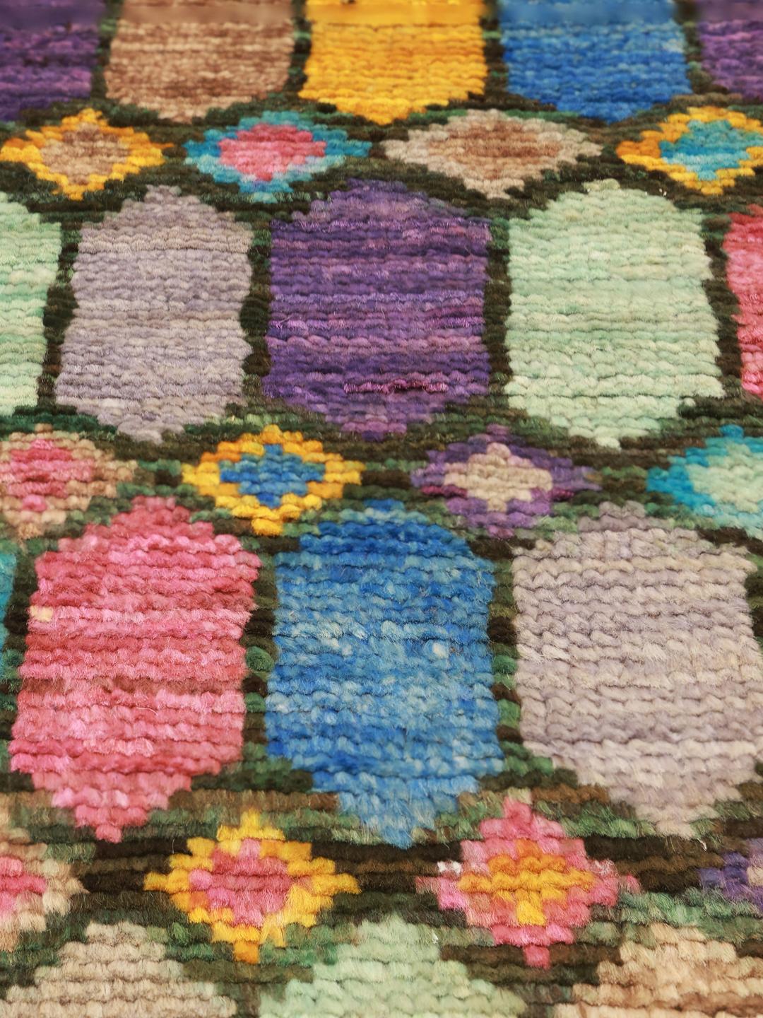 A vibrant rectangular Berber rug from Afghanistan with a colourful geometric pattern.