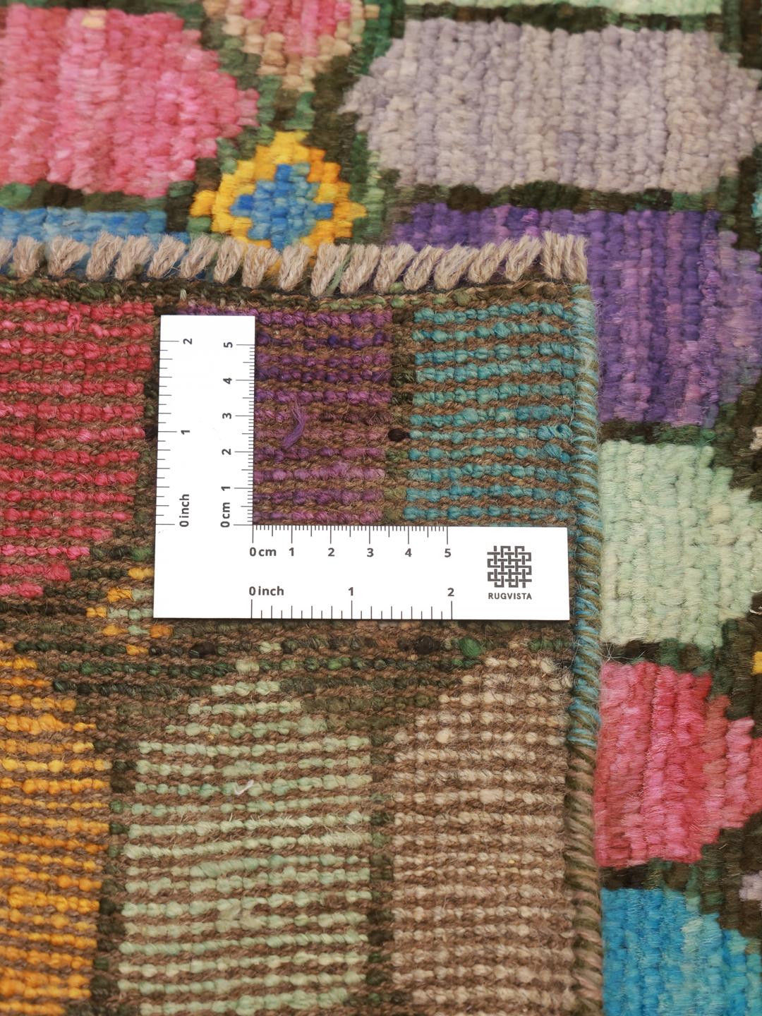 A vibrant rectangular Berber rug from Afghanistan with a colourful geometric pattern.