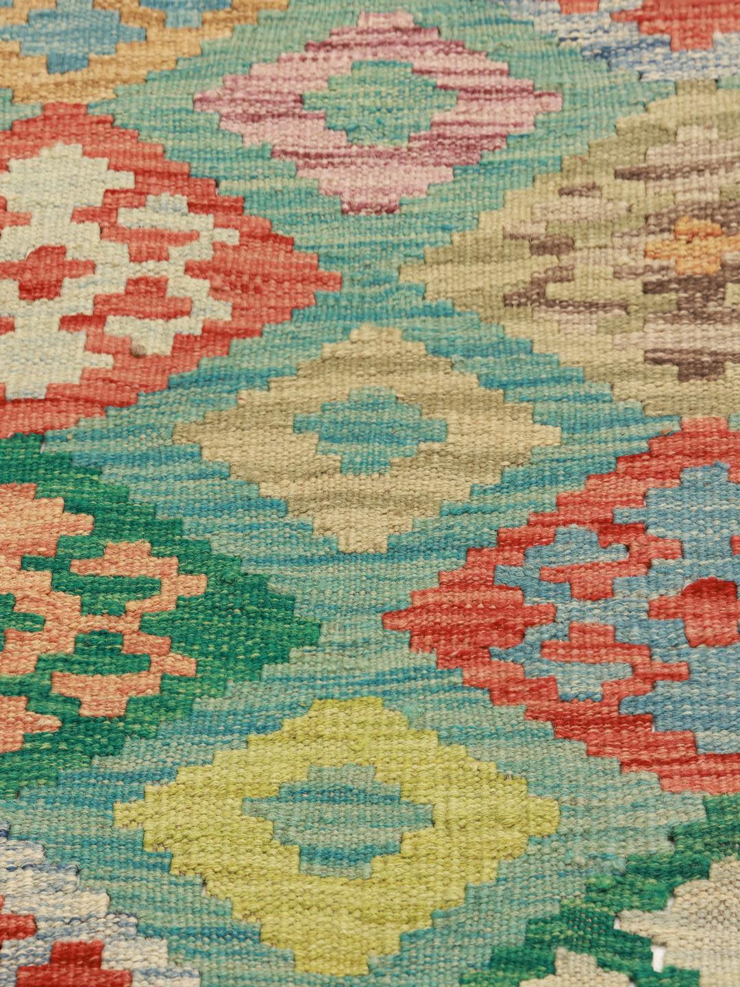 Duży, prostokątny, ręcznie tkany dywan typu afgański kilim z kolorowym geometrycznym wzorem w romby i medaliony.