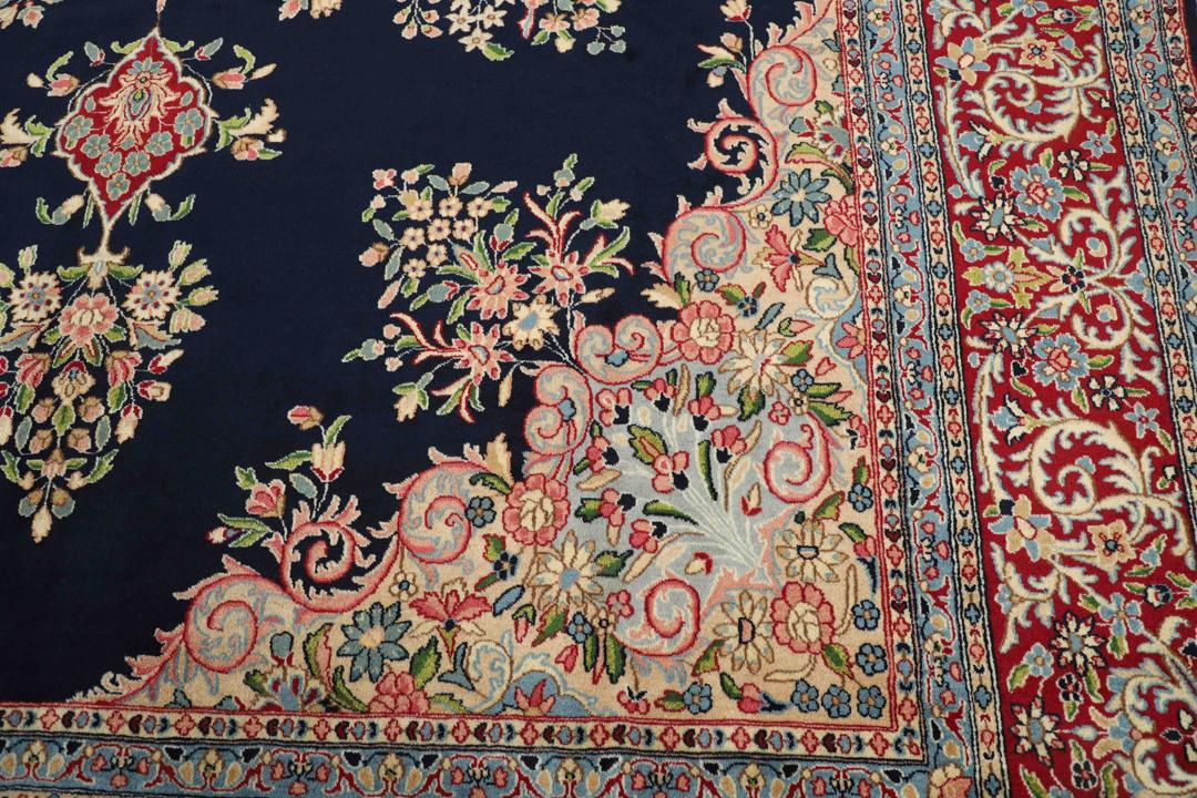 Handgeknoopt Kerman-tapijt uit het Midden-Oosten met een donkerblauw veld en sierlijke bloempatronen.