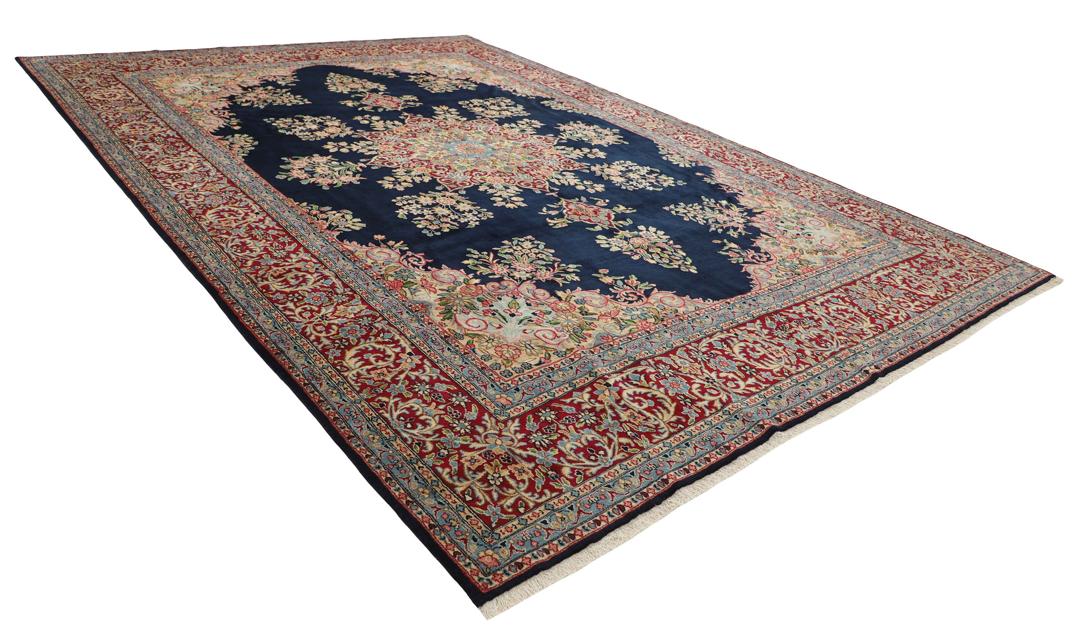 Handgeknoopt Kerman-tapijt uit het Midden-Oosten met een donkerblauw veld en sierlijke bloempatronen.