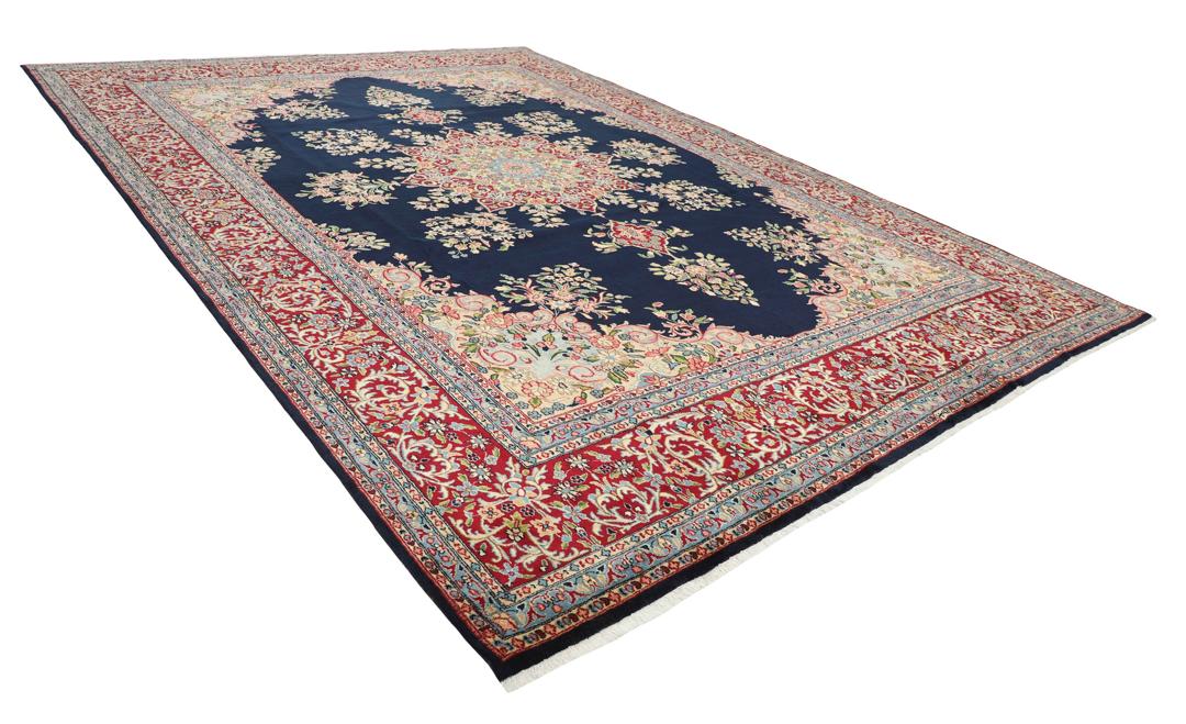 Handgeknoopt Kerman-tapijt uit het Midden-Oosten met een donkerblauw veld en sierlijke bloempatronen.