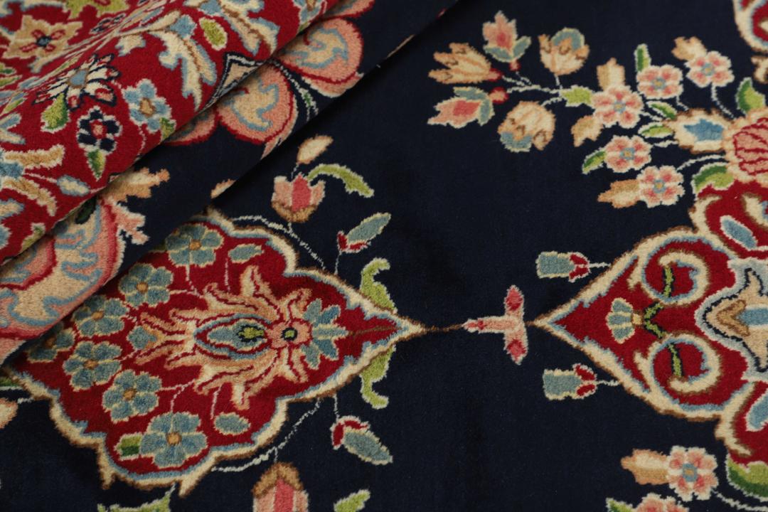 Handgeknoopt Kerman-tapijt uit het Midden-Oosten met een donkerblauw veld en sierlijke bloempatronen.