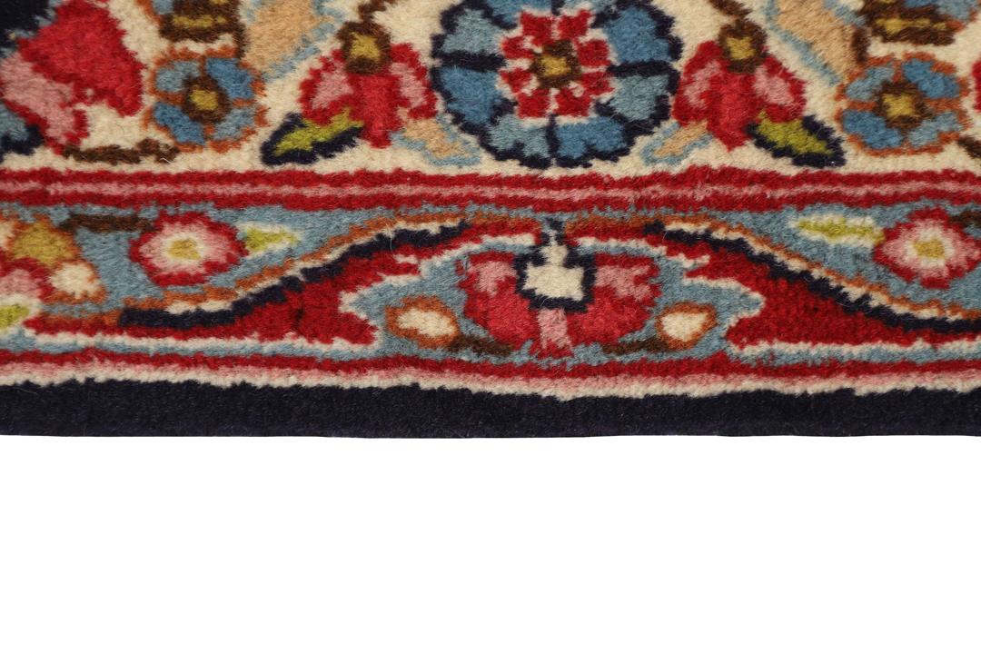 Een groot, handgeknoopt Kerman-tapijt uit het Midden-Oosten met een donkerblauw veld en een veelkleurig bloemenmedaillon.